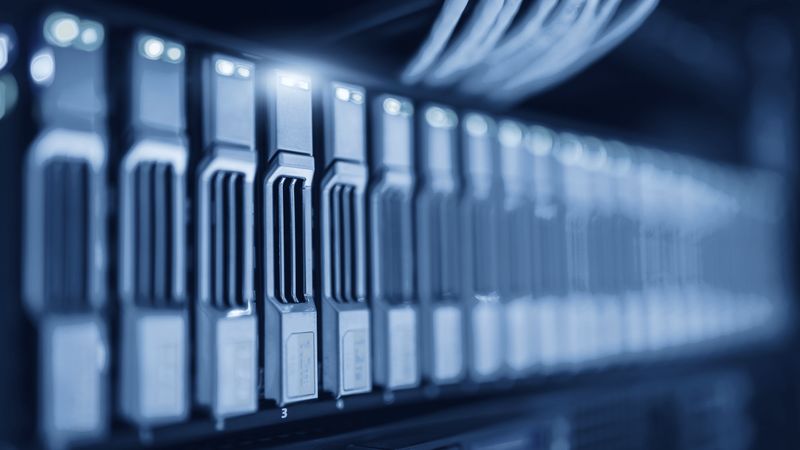Server cabinets in a data centre under blue lighting.
